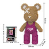 A brown bear figure made of micro building blocks, standing upright, with a pink apron and white markings.