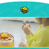 A child is interacting with a yellow and orange reflex training toy shaped like a duck, demonstrating fine motor skills.