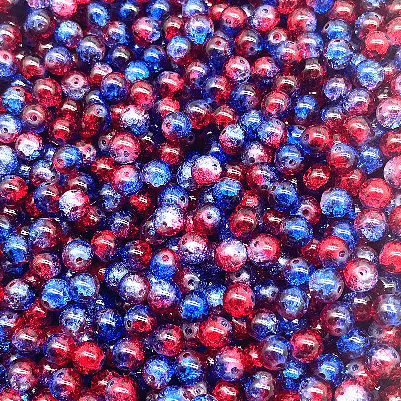 A close-up view of small, round glass crackle beads in shades of red, blue, and purple.