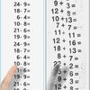 A hand is pressing a roller stamp onto a sheet of paper showing various addition and subtraction math problems.