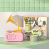 A pink card phonograph toy with a yellow horn and several stacks of learning cards displayed on a light surface.