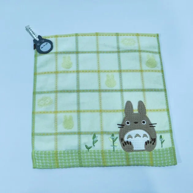 A light green plaid fabric towel featuring a cute gray rabbit design and a small tag.