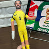 A yellow football star stuffed doll with flexible joints wearing a yellow jersey and white gloves.