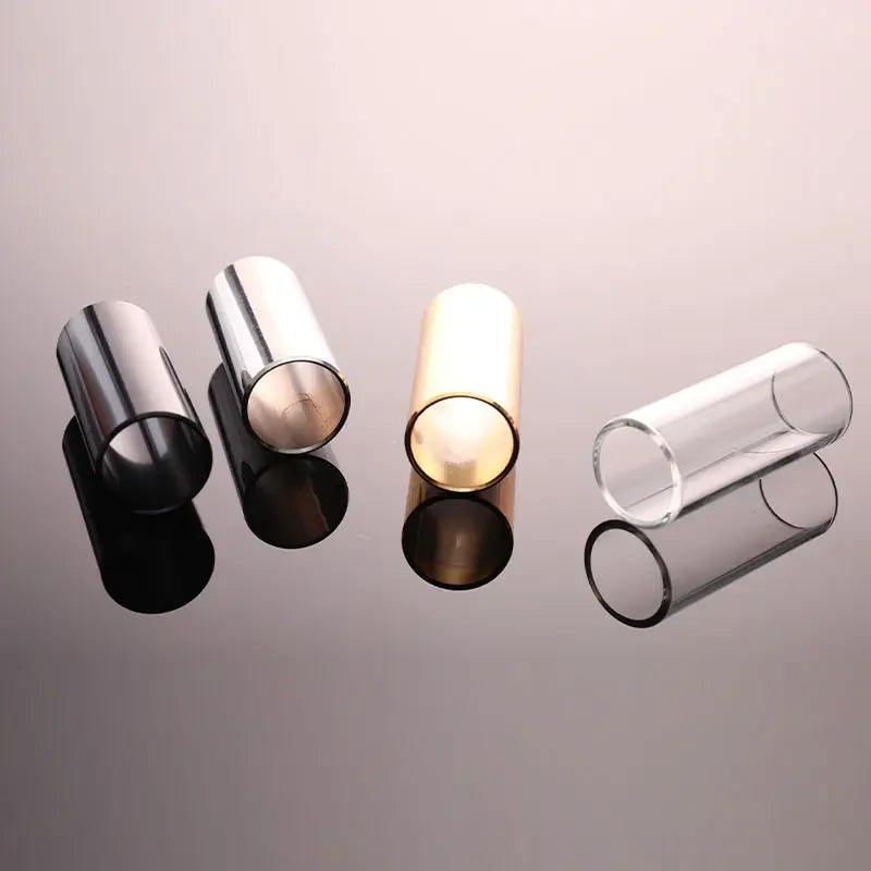 Three precision guitar slide bars are displayed: two stainless steel and one glass, reflecting light.