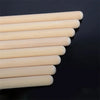 A row of light-colored maple wood drumsticks arranged diagonally against a dark background.