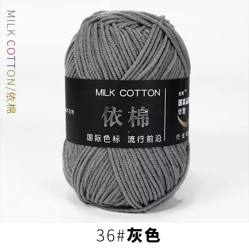 A ball of gray milk cotton yarn with a black label and Chinese text for knitting and crochet