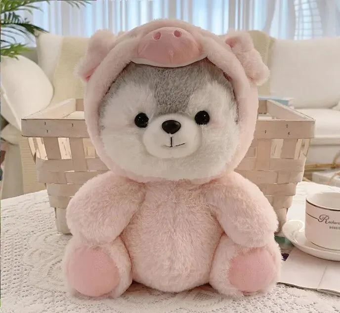 A pink husky plush toy with soft fur is sitting on a white lace tablecloth.