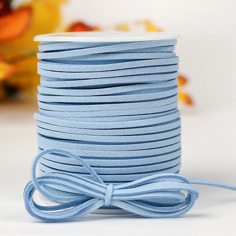 A stack of light blue velvet faux suede braided ribbon rolls for crafting and gift wrapping.