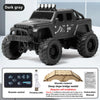 A dark gray 1:64 scale off-road RC car model with 4x4 features and remote control accessories.