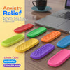 A collection of colorful silicone fidget strips for anxiety relief and meditation, laid out on a wooden desk.
