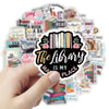 A hand holds a sticker featuring the text The Library Is My Place surrounded by various book-themed stickers.