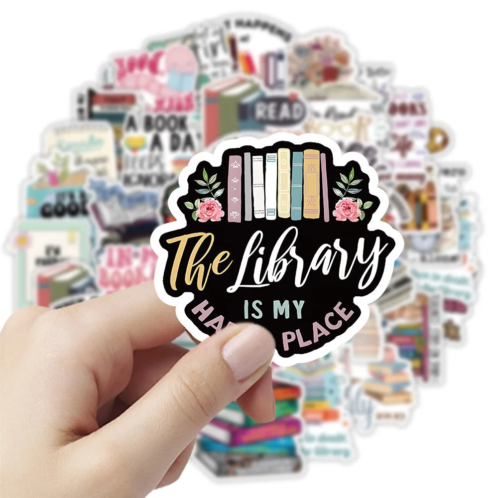 A hand holds a sticker featuring the text The Library Is My Place surrounded by various book-themed stickers.