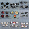 A collection of enamel pins featuring various cats in different expressions and styles.