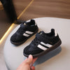 A pair of black and white casual sneakers resting on a white surface.
