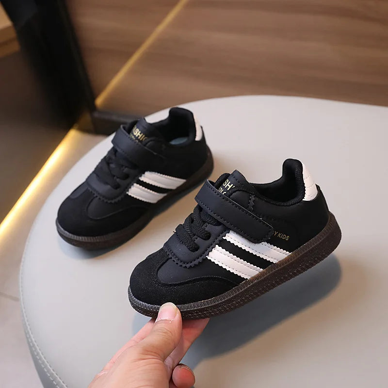 A pair of black and white casual sneakers resting on a white surface.