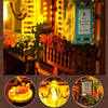 A miniature wooden dollhouse kit featuring furniture displayed in a warm, illuminated setting.