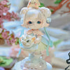 A delicate figurine of a girl with light pink hair and large blue eyes, wearing a light blue dress and holding a small white 