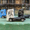 Three diecast alloy container trucks in blue, white, and black are displayed on a green surface.
