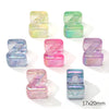 A collection of colorful acrylic alphabet beads in various shades of green, blue, and pink, shaped like the letter Z.