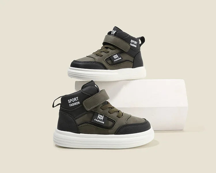 A pair of dark olive green and black kids' high-top sneakers with white soles and velcro straps.