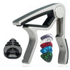 A silver guitar capo set featuring a clamp, picks, and a holder.