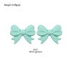 A pair of mint green silicone bow tie beads for jewelry making and craft projects.