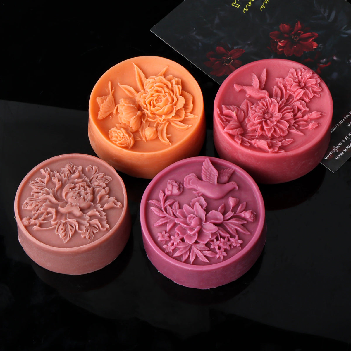 Three silicone molds shaped like roses and flowers in peach, pink, and mauve tones for crafting.