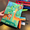 A soft sensory cloth book featuring jungle animals like an elephant and giraffe on a green background.