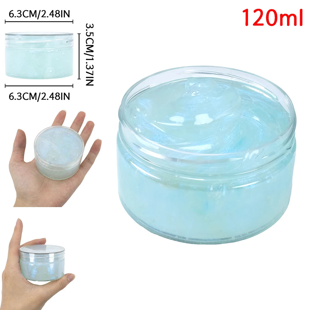 A clear glass jar of light blue glitter slime putty with a lid, shown next to a hand for scale.