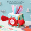 A colorful tissue box sensory toy for babies featuring an ocean theme and a mirror.