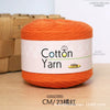A ball of bright orange 100% cotton yarn is displayed on a wooden surface.