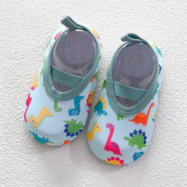 A pair of colorful baby barefoot water shoes featuring various dinosaur patterns.