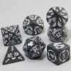 A set of polyhedral dice featuring a marble dragon pattern in black and white on a gray background.