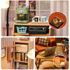 A miniature house kit is displayed on a wooden shelf next to a coffee grinder and various decorative items.