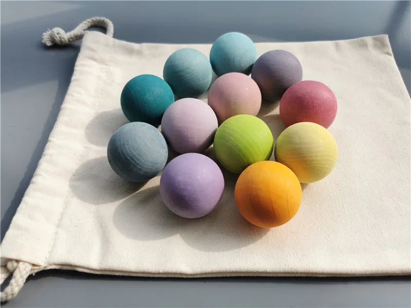 A collection of colorful, smooth, spherical sensory music trees or marbles arranged on a light fabric.