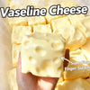 A hand holds a block of Vaseline cheese, a squishy stress relief toy.