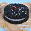 A black squishy stress relief toy with colorful confetti on top, shown on a wooden cutting board.