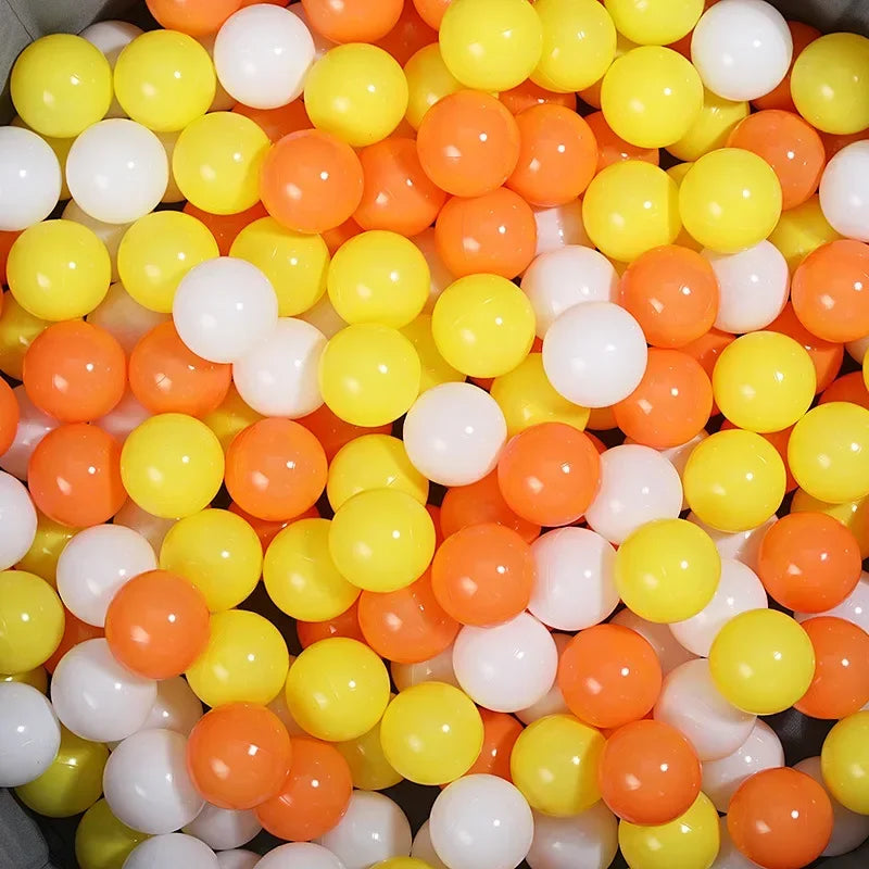 A close-up view of a large pack of colorful play balls in various shades of yellow, orange, and white.