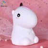 A white unicorn LED night light with a pink horn sitting on a pink background.