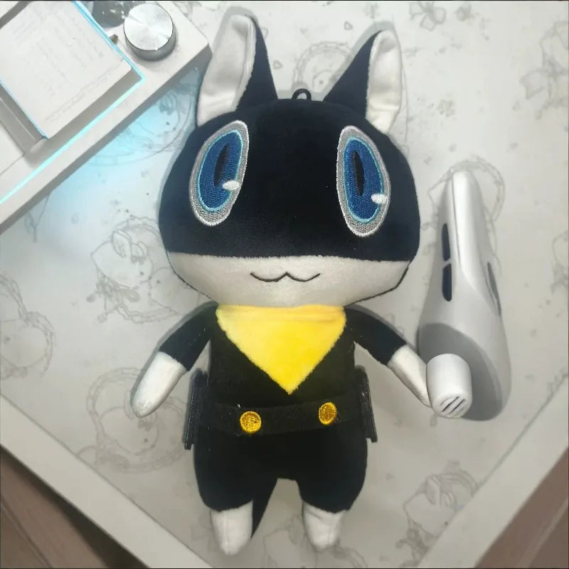 A black and white plush doll of Persona 5 Morgana with large blue eyes and yellow clothing.