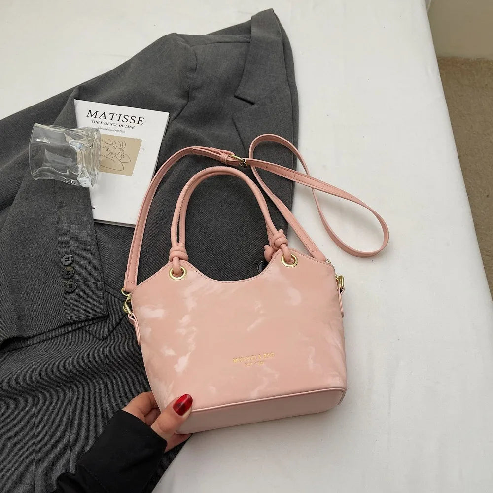 A pale pink floral canvas tote bag is shown next to a gray blazer and a piece of paper.