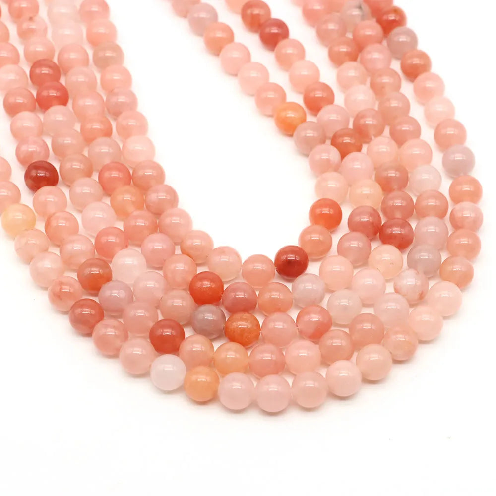 A strand of round rose quartz, amethyst, and red silk jade beads for jewelry making.