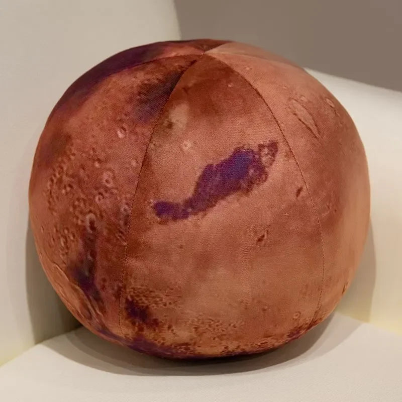 A round, brown plush toy resembling a celestial body with purple markings.