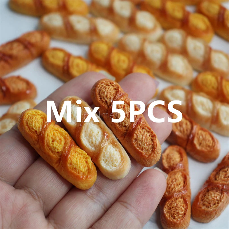 A hand holds a set of five miniature baguette-shaped bread items.
