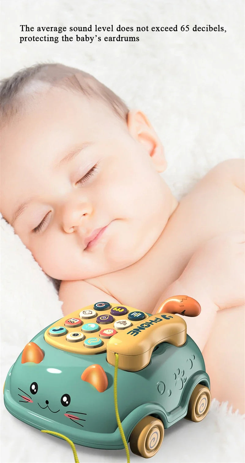A light green toy phone shaped like a car with cat ears and wheels, resting on white fur, used for babies.