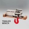 A silver trailer winch is shown on a wooden base, with a red hook attached.