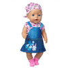 A baby doll wearing a pink and blue outfit set with a cat print shirt and matching headwear.