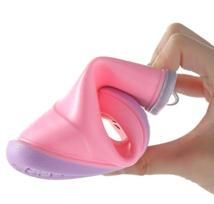 A hand holds a pink and purple kids' rain boot, showing the flexible design.