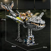 A detailed mechanical model of a dragonfly built from grey and metallic parts, displayed on a stand.