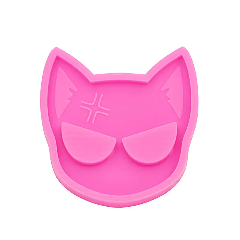 A pink silicone mold shaped like a cat head for DIY keychains and craft projects.